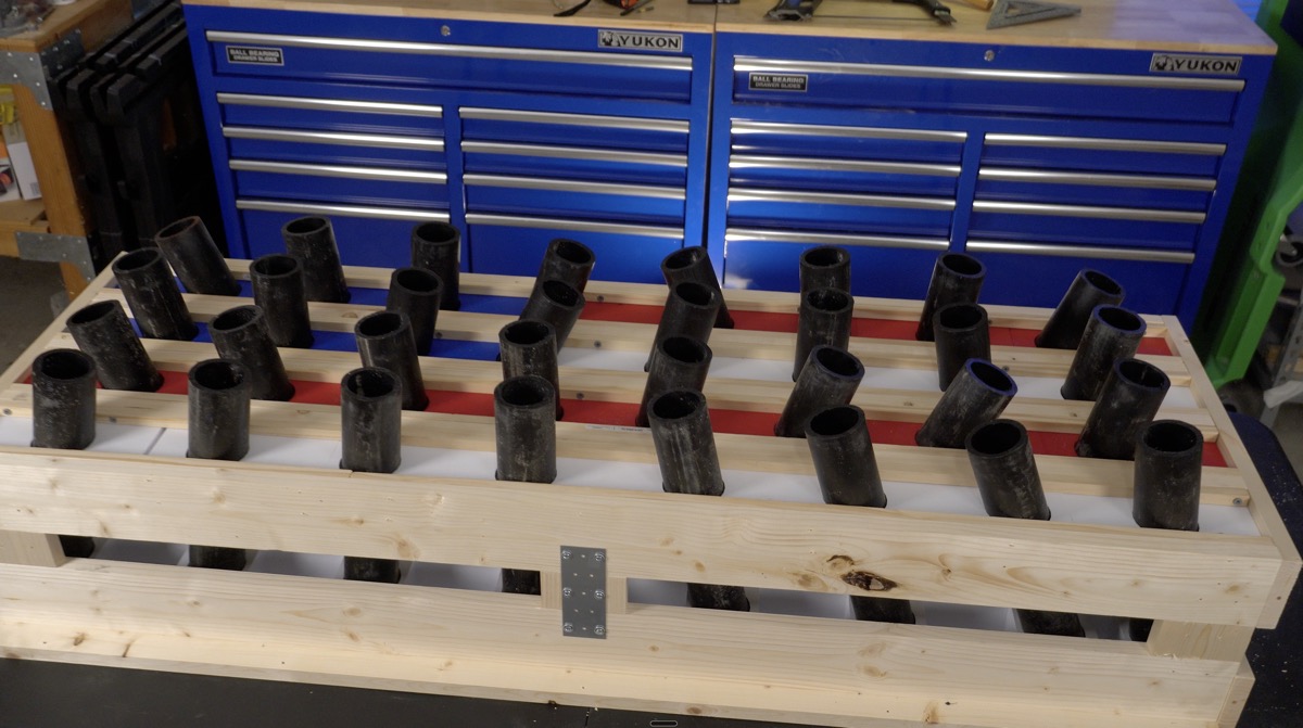 Completed mortar rack with all HDPE tubes loaded, sitting on a workbench