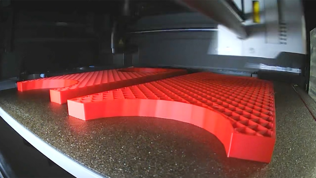 Bambu P1S printing red 3D-printed mortar-rack spacer parts mid-job