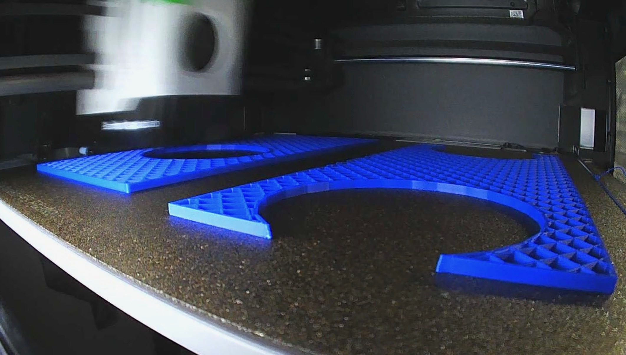 Stack of freshly 3D-printed mortar-rack collars and bottom blocks in blue PLA on the workbench