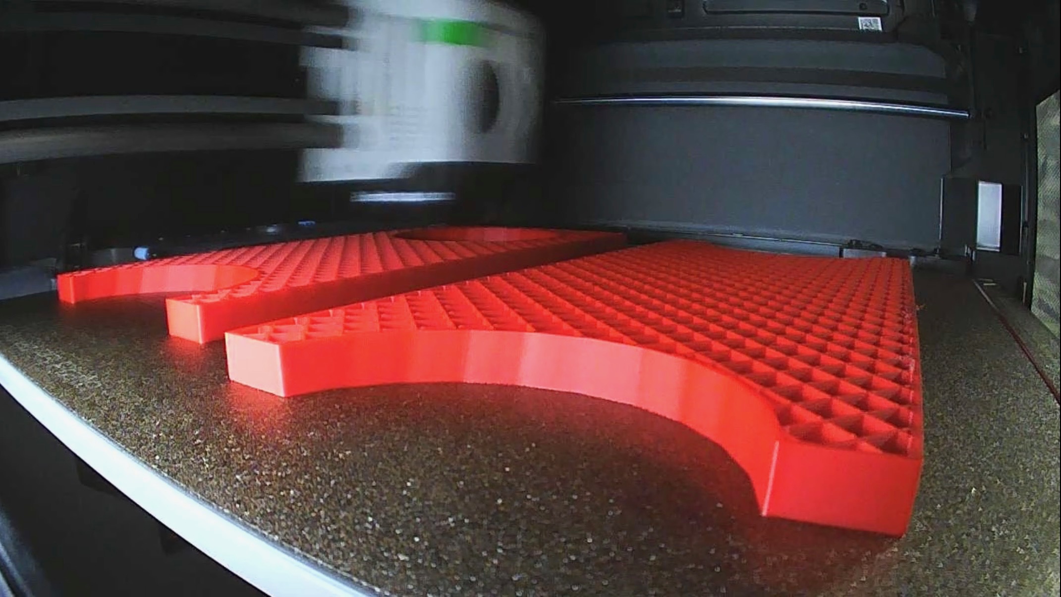 A stack of freshly 3D-printed mortar-rack collars and bottom blocks in red PLA
